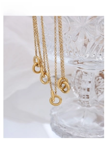 Detailed close-up of interlocking gold-plated circular pendants on elegant thin chains