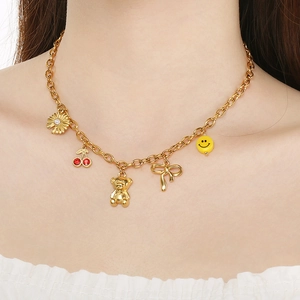 Gold stainless steel link necklace with flower, cherry, and bear charms worn by a model