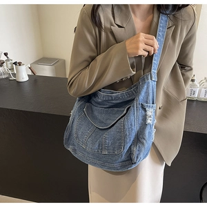 Gros plan du sac fourre-tout en denim bleu vintage avec bords usés et surpiqûres
