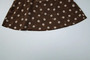 Détail du tissu en mousseline marron café à pois avec une texture translucide douce