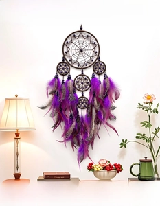 Detail of handmade dream catcher with layered brown rings and purple feathers for wall decor