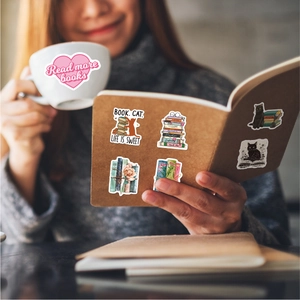 Waterproof reading-themed stickers shown on a mug and notebook with cats and books motifs