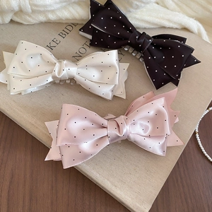 Detailed set of three satin polka dot bow hair clips in black, pink, and ivory colors
