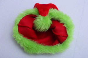 Detail of red Christmas elf hat featuring neon green faux fur trim and fluffy pompom