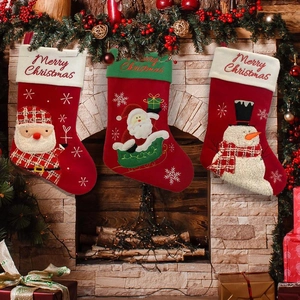 Close-up of three hanging Christmas stockings with snowman and Santa Claus embroidery