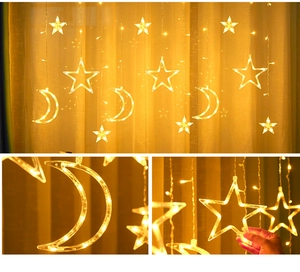 Detail of warm yellow LED star and moon curtain lights with hanging acrylic ornaments