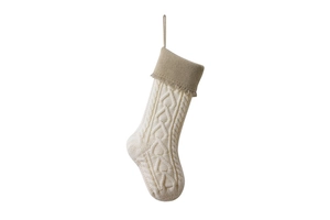 Close-up of cable knit Christmas stocking featuring cream and coffee tones and tassel