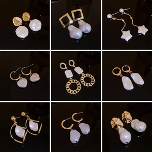 Set of nine baroque pearl and golden star earrings for women on dark background