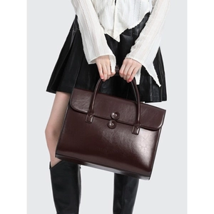 Deep brown leather briefcase handbag shown on model for professional daily commute look