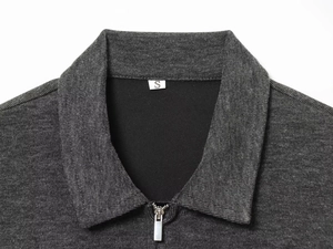 Detail of dark grey ribbed knit top featuring a silver half-zip collar and size S label