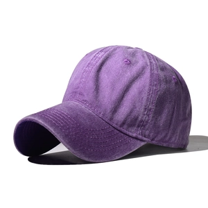 Detailed close-up of dark purple washed cotton baseball cap with visible stitch texture