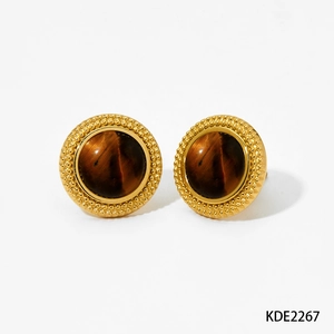 Macro detail of round golden stud earrings with brown tiger eye stone and beaded frame