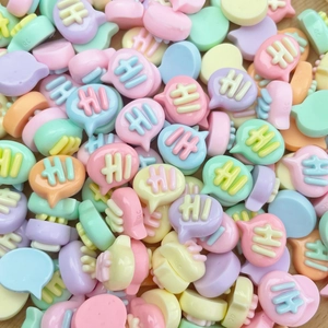 Macro view of colorful resin Hi speech bubble charms for DIY nail art and crafts