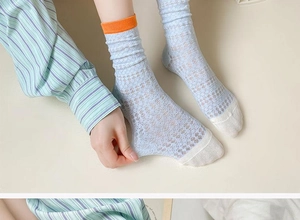 Detailed view of light blue mesh socks with vibrant orange ribbed cuffs for women