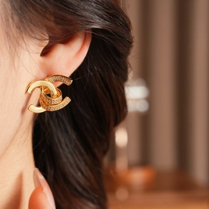 Close-up of model wearing 18k gold plated double C earrings with paved cubic zirconia