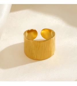 Macro shot of 18K gold plated wide band ring featuring textured irregular vertical bark patterns