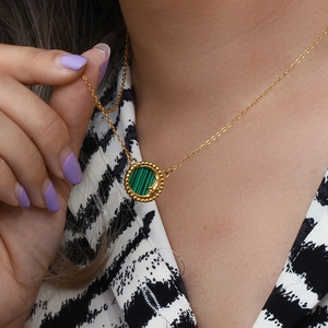 Close-up of gold moon and star engraved necklace with green malachite heart pendant
