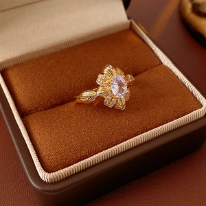 Makroaufnahme eines Vintage Goldrings mit violettem Stein und Zirkonia-Blumenmuster