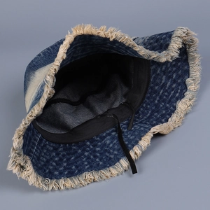 Close-up of denim bucket hat featuring frayed edges and adjustable inner drawstring