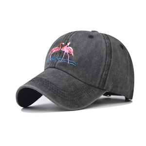 Detail of pink flamingo embroidery on washed charcoal grey cotton baseball cap