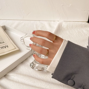 Detail of elegant gold knot rings worn on fingers with a minimalist lifestyle backdrop