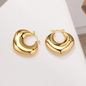 Detailed view of chunky gold hollow U-shaped hoop earrings with polished finish