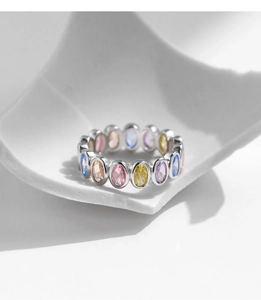 Macro view of silver S925 ring with colorful oval-cut zircons on ceramic surface
