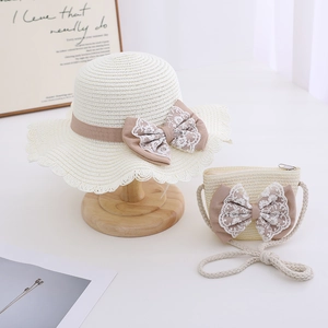 Detail view of girls straw hat and matching bag set with lace bows and wavy edges