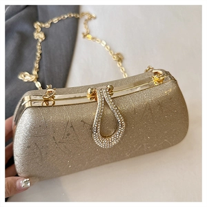Detail of champagne gold glitter evening bag with rhinestone clasp and metal chain strap