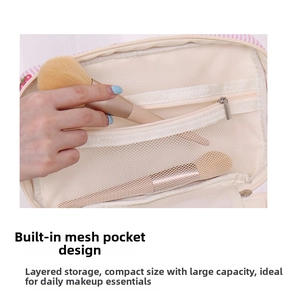 Detail view of the interior layered mesh pocket for makeup brush storage inside the bag