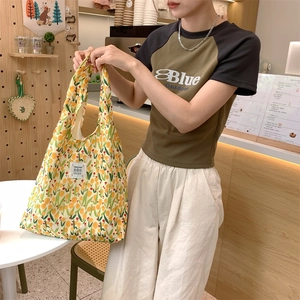 Dettaglio della borsa shopper in tela leggera con stampa di tulipani gialli e toppa in tessuto