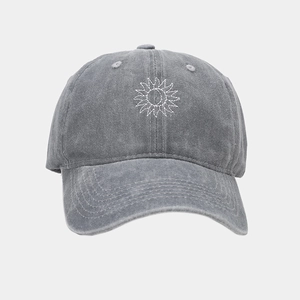 Détail de la broderie soleil sur casquette de baseball en coton gris délavé style vintage