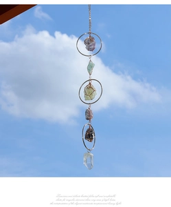 Detailed close-up of natural amethyst and citrine stones in a metal hanging suncatcher