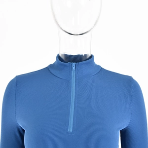 Detail of blue ribbed knit top featuring a quarter-zip high neck collar and shoulder fit
