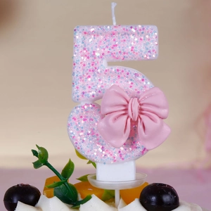 Detailed macro view of pink glitter number 5 birthday candle with a decorative 3D bow