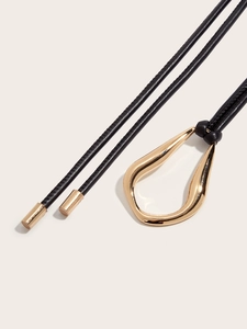 Macro view of minimalist black leather cord necklace with organic gold water drop pendant