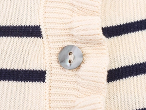 Gros plan détaillé du cardigan en maille rayé beige et bleu avec bouton en nacre