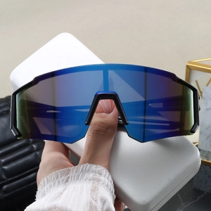 Detail of oversized sports sunglasses with blue gradient lens and white leather case