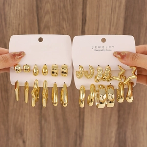 Set of 12 pairs of vintage gold C-shaped hoop earrings with geometric star and twist designs