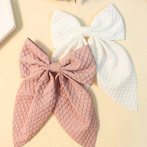 Close-up of pink and white quilted fabric bow hair clips with elegant long tails