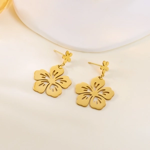 Close-up of golden hollow flower earrings with intricate layered petal design