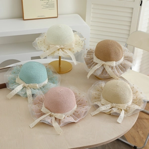 Detail of children's wide brim straw sun hats featuring polka dot mesh and lace bows