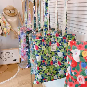 Detail of floral printed canvas tote bags hanging on a rack in a bright boutique room