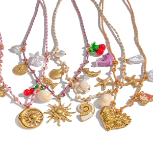 Bohemian colorful woven rope necklaces with gold sun, heart, and pearl charms on white base