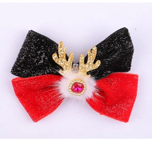Detail of Christmas reindeer antler hair clip with red gem and sparkly bow tie