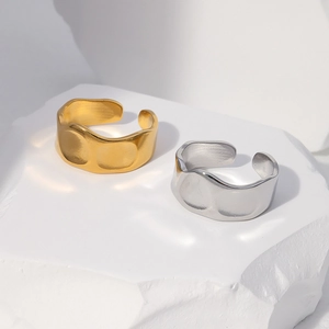 Detail of gold and silver irregular hammered texture rings on white stone base