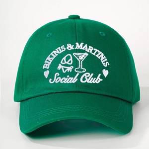 Detail of white embroidery with Bikinis and Martinis text on a dark green baseball cap