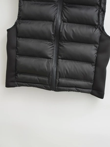 Detail of glossy nylon and matte contrast stitching on a quilted black vest jacket