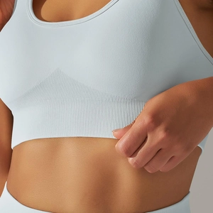 Close-up of seamless light blue yoga bra featuring wide ribbed support band and elastic knit