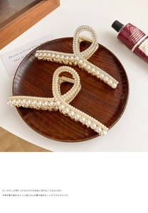 Détail de deux pinces à cheveux en perles avec strass sur un plateau en bois